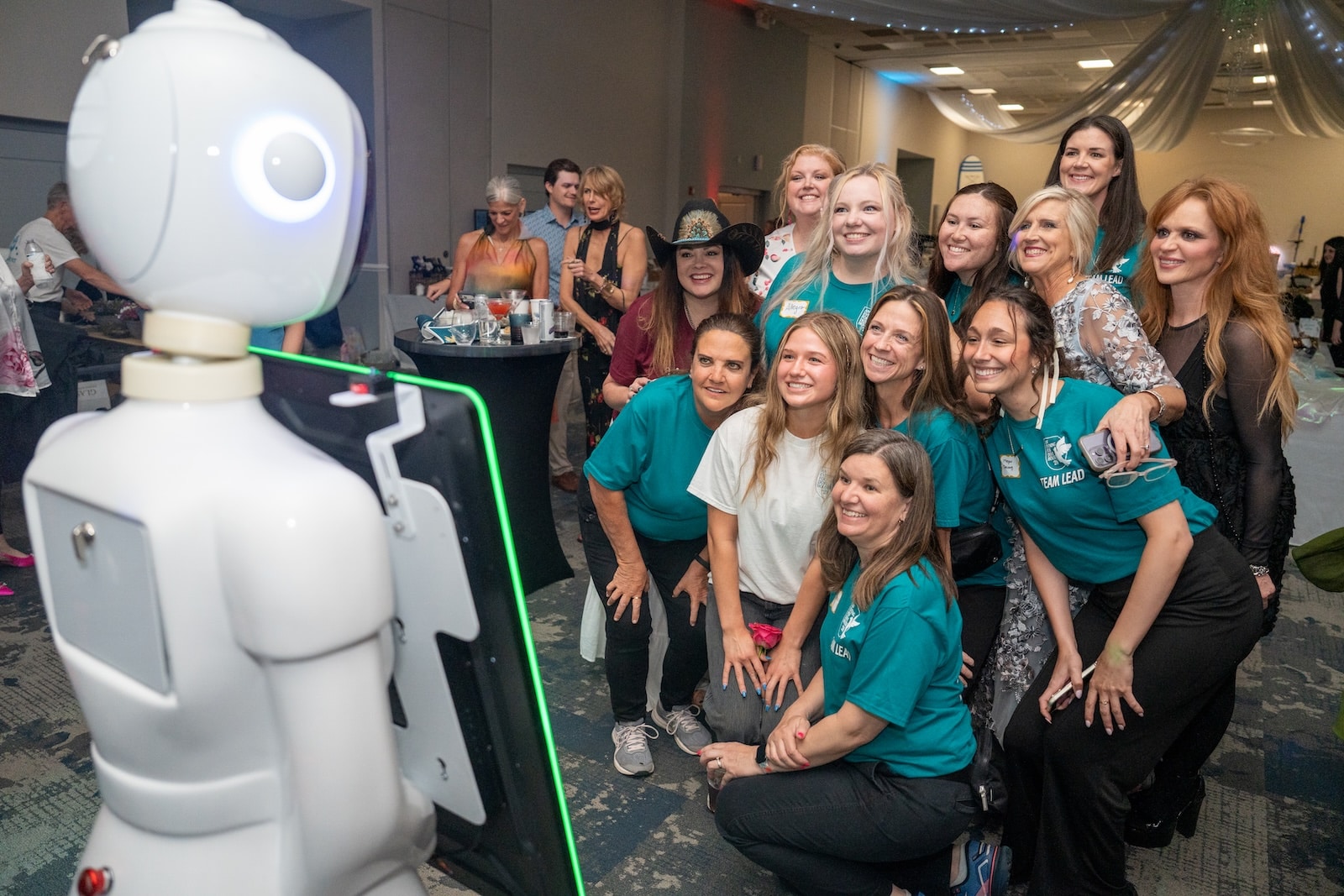 Guests posing with an AI robot photo booth at The Charles Mack Citizen Center near Lake Norman in Mooresville, NC
