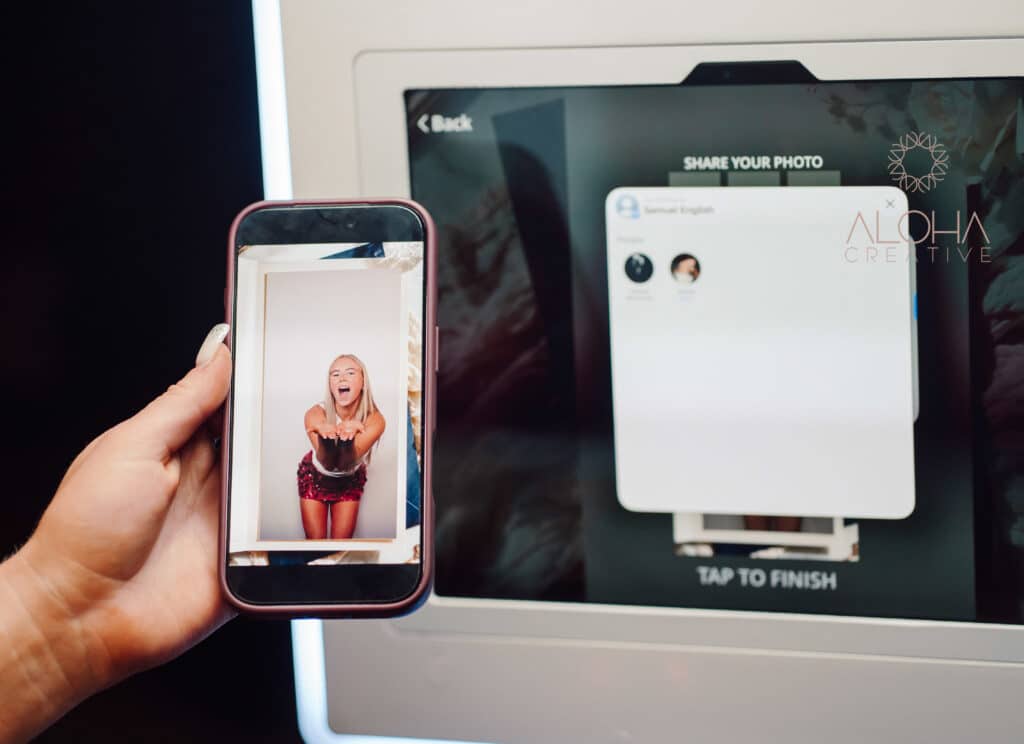 Guest holding a phone playing a birthday party photo booth video just shared by AirDrop in Charlotte, NC