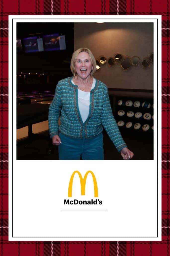Smiling woman in a teal outfit posing joyfully in a bowling alley, with a McDonald's logo at the bottom of the image.