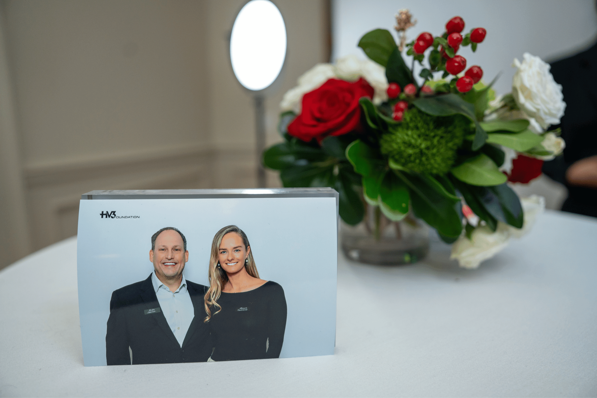 Framed photo booth print of couple displayed on tabletop next to Aloha Creative's premium photo booth at a Tega Cay corporate gala