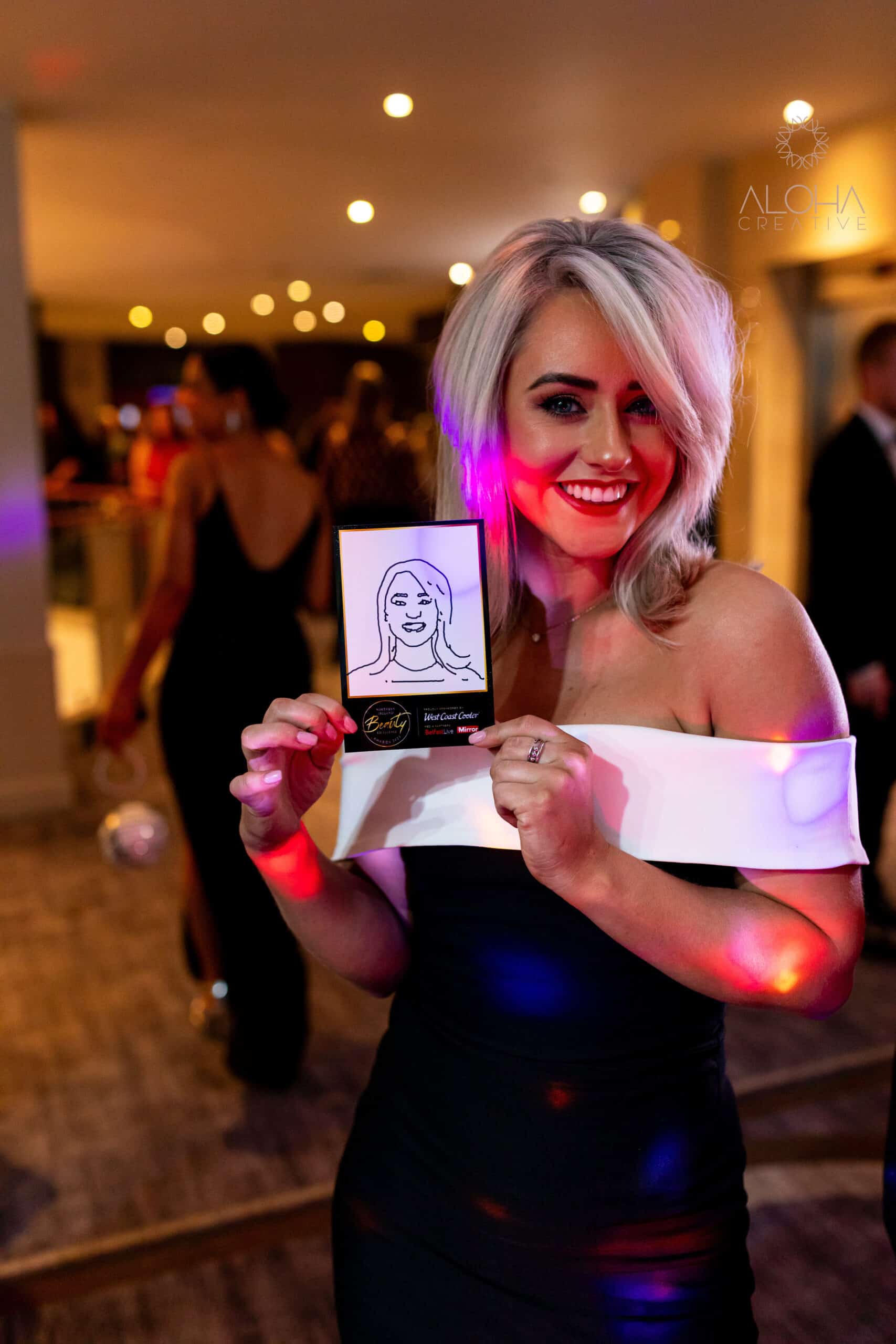 This is a photo of a guest holding her caricature sketchbot at a work party. Photo was taken with our digital selfie booth and the photo was then drawn by our sketchbots.